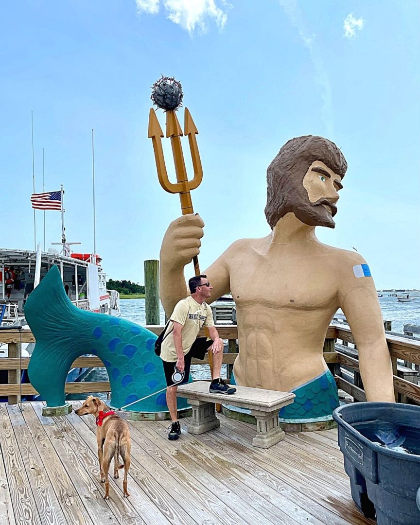 Morehead City King Neptune statue has Covid vaccine bandaid on and has speared the Corona Virus with his trident