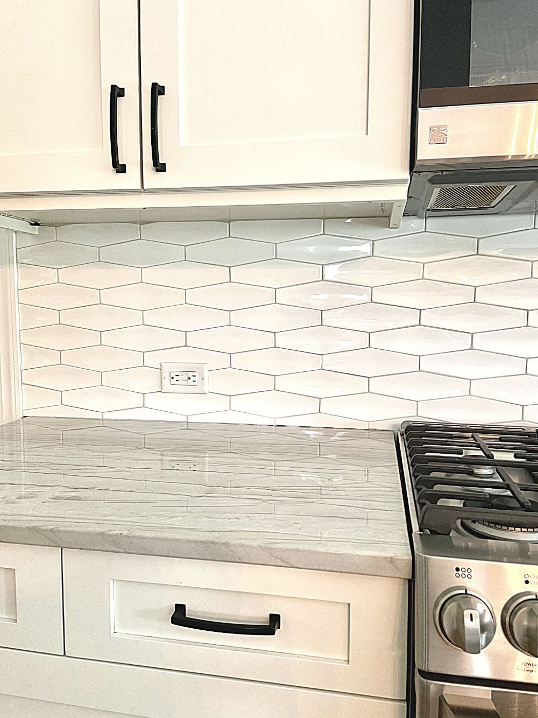 White elongated hexagon tile backsplash with white mustang quartzite countertop and Benjamin Moore Classic Gray Cabinets